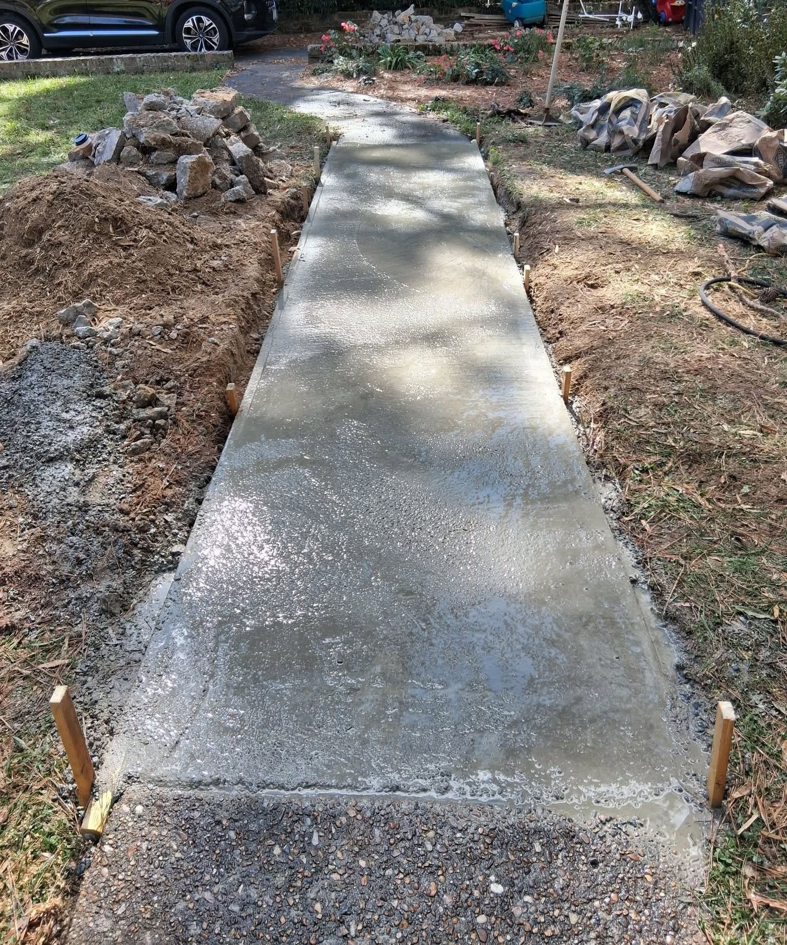 Freshly poured walkway completed through a landscaped yard